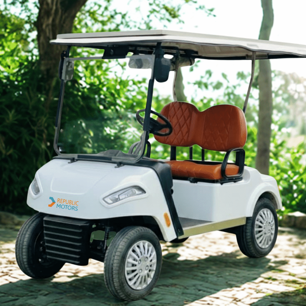 2 seater golf cart with orange seat on the green ground, forest background and sun shining on the golf cart but with different angle